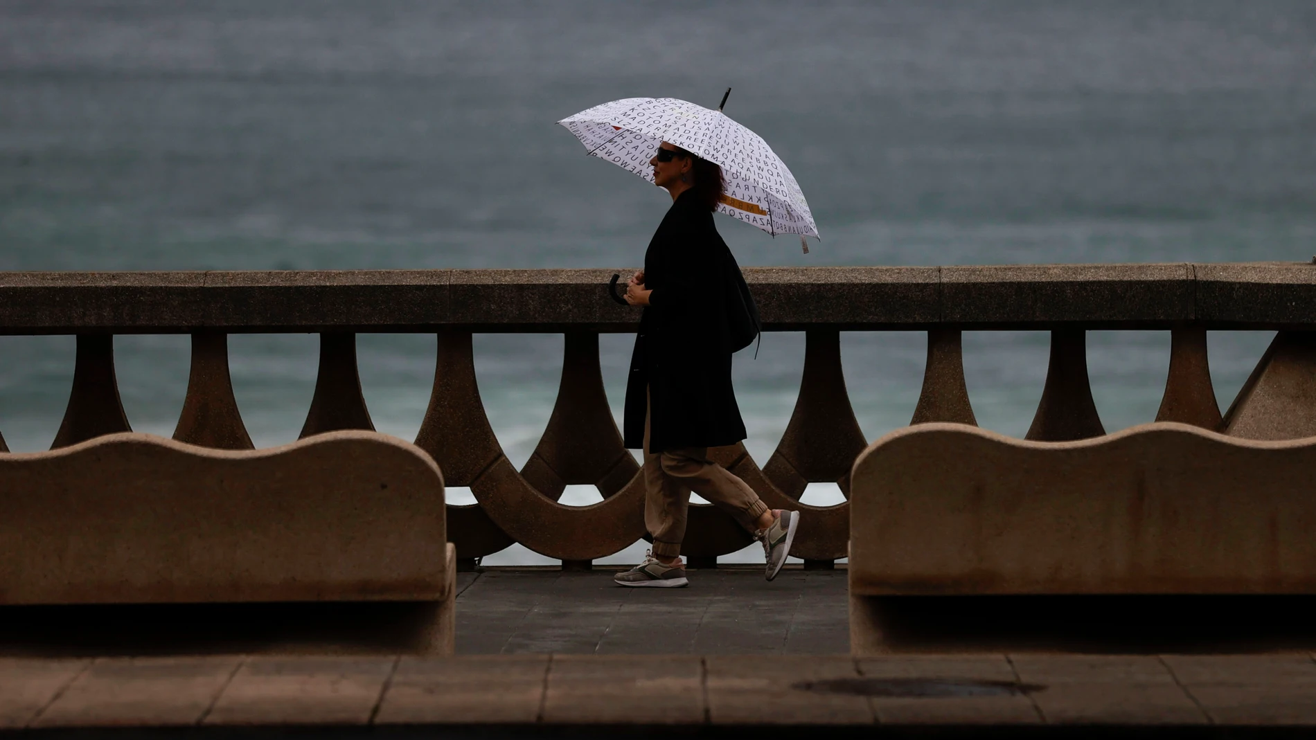 Una mujer camina por el paseo marítimo de A Coruña
