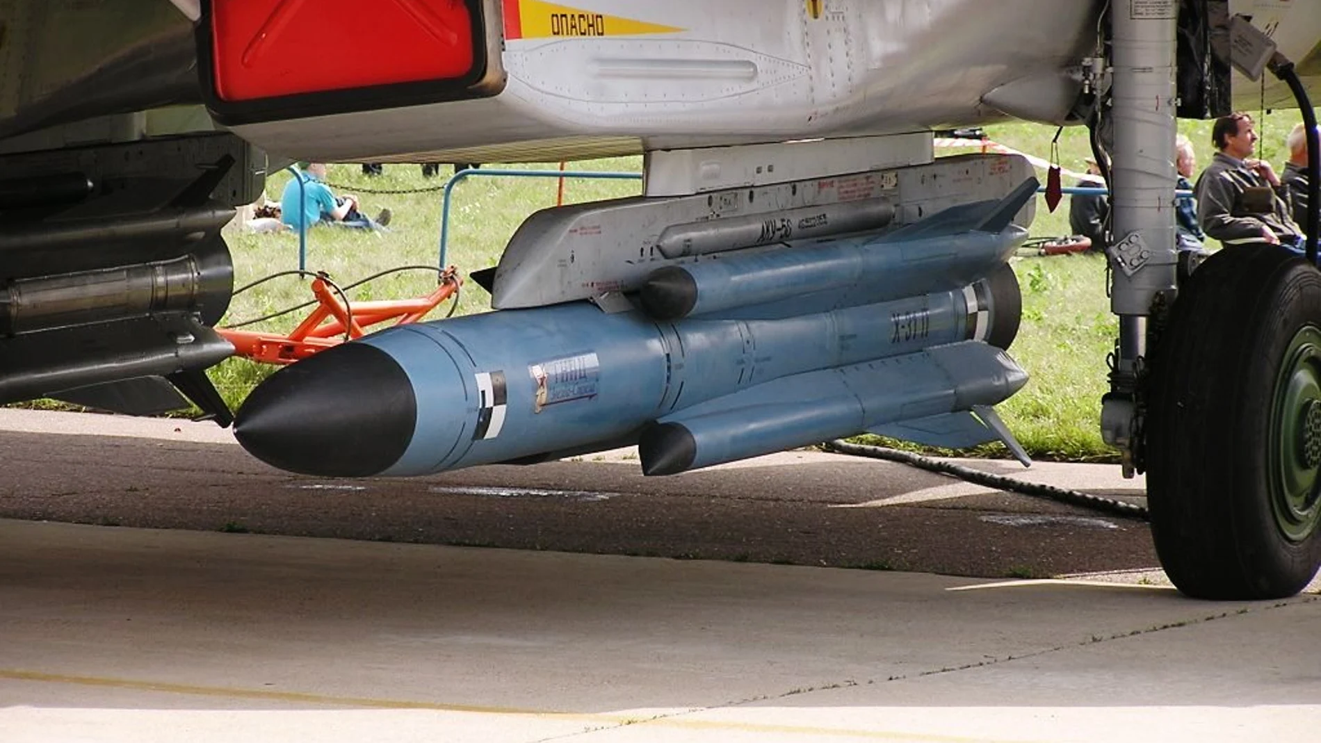 Misiles de color azul colocados e instalados debajo de un avión de combate