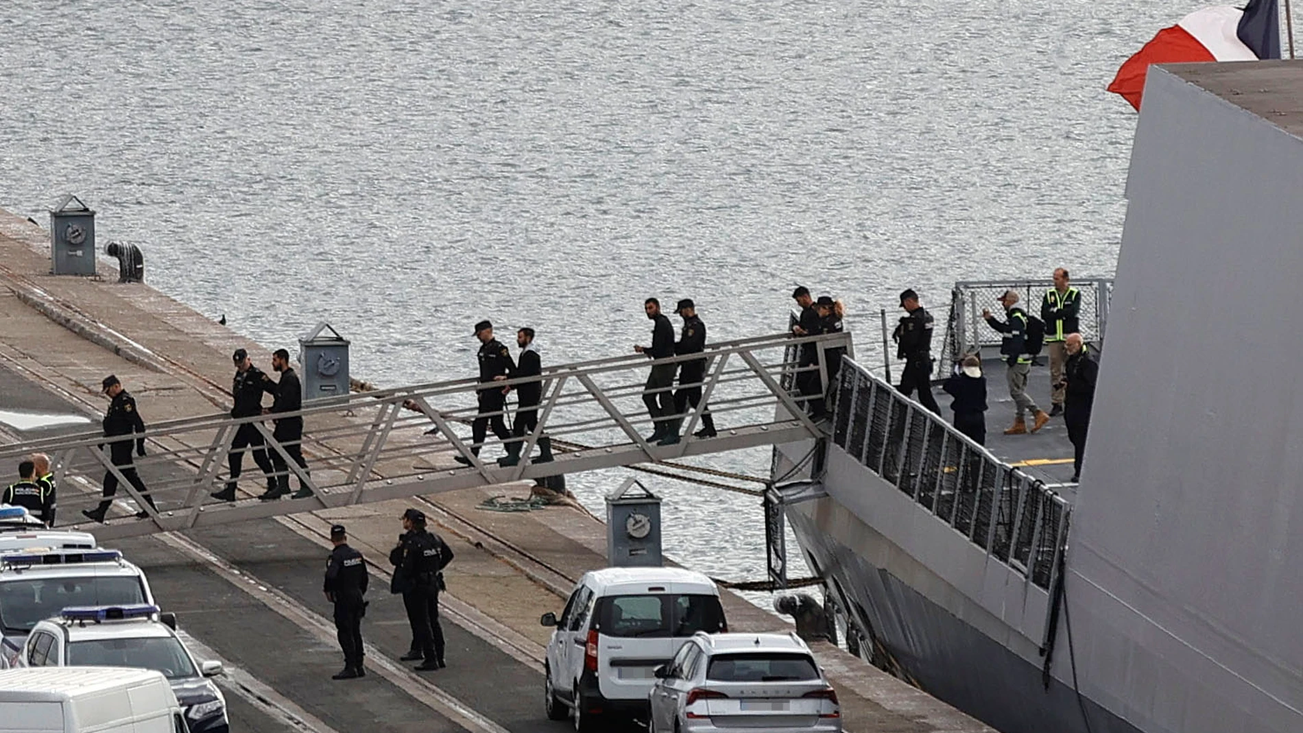 A CORUÑA, 22/10/2025.- La Policía Nacional, en colaboración con autoridades francesas, ha incautado más de 1.500 kilos de cocaína en un barco francés que se encuentra atracado en el muelle de Calvo Sotelo, en A Coruña. En la imagen, traslado de los detenidos a los furgones policiales. EFE/Cabalar