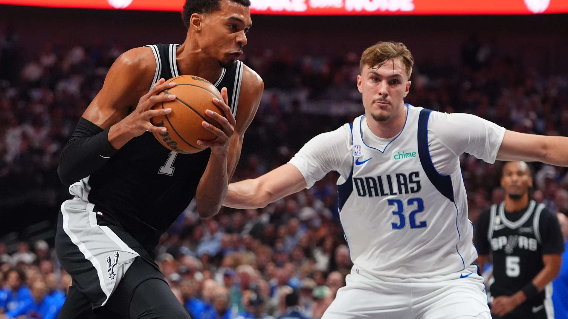San Antonio Spurs forward Victor Wembanyama (1) drives against Dallas Mavericks forward Cooper Flagg (32) during the first half of an NBA basketball game in Dallas, Wednesday, Oct. 22, 2025. (AP Photo/LM Otero)