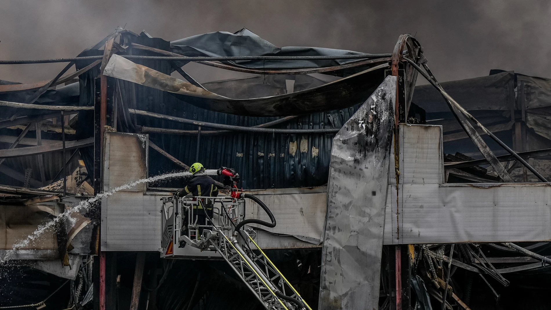 A firefighter works to extinguish a fire at a warehouse following a Russian attack, Saturday, Oct. 25, 2025, in Kyiv, Ukraine. (AP Photo/Julia Demaree Nikhinson)