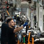 Empleados trabajan en la cadena producción Empleados trabajan en la cadena producción