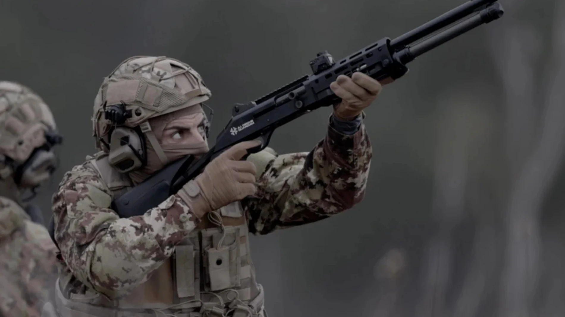 Soldado con uniforme de camuflaje equipado con una escopeta táctica