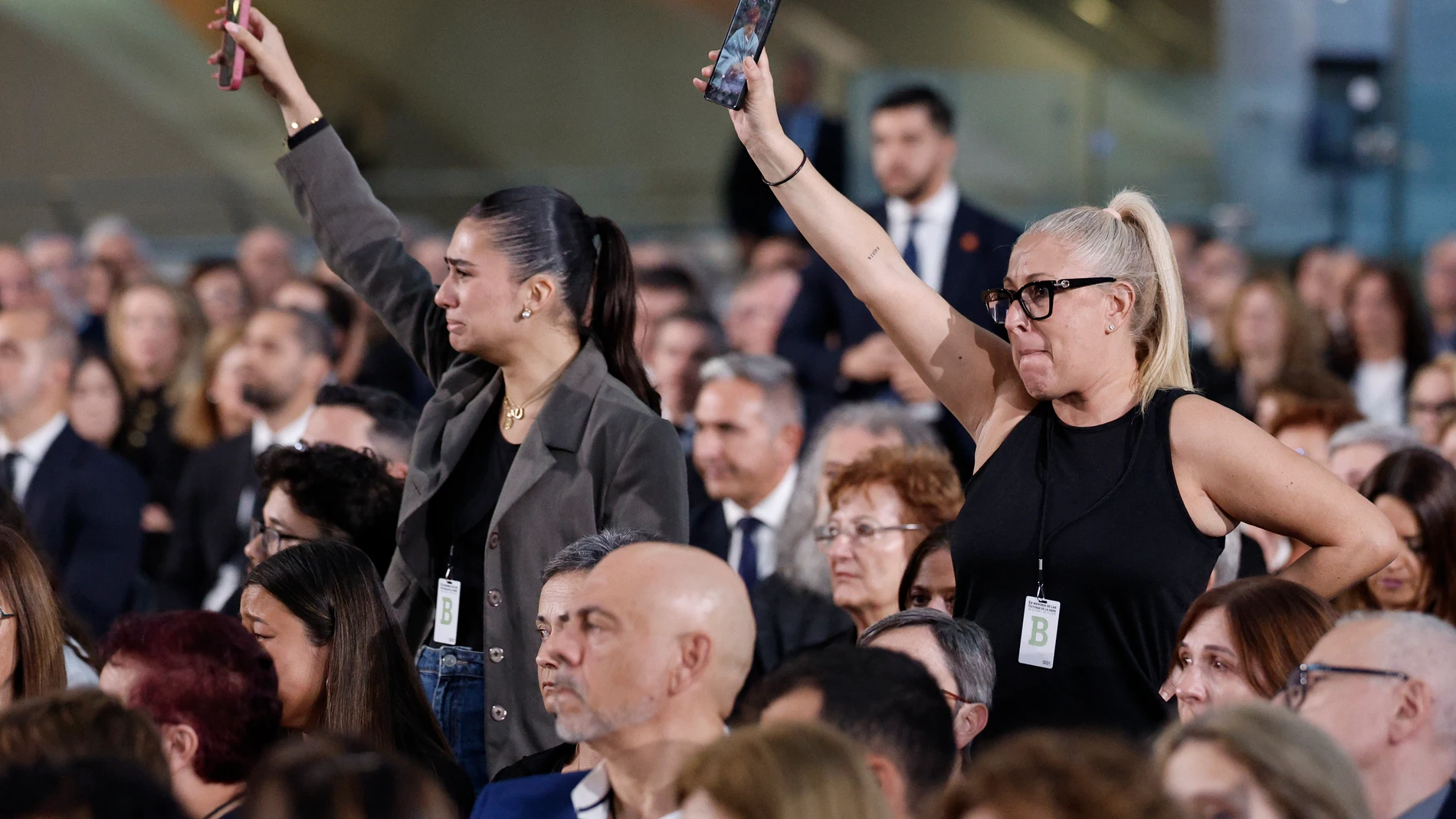 VALENCIA, 29/10/2025.- Varios de los familiares de las 237 víctimas de la dana muestran fotografías de los seres queridos fallecidos durante el funeral de Estado celebrado este miércoles en Valencia con motivo del primer aniversario de la tragedia. EFE/ Kai Forsterling