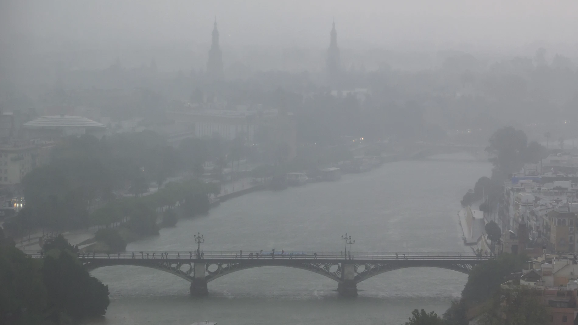 GRAFAND1428. SEVILLA, 29/10/2025.- Imagen de Sevilla con el Puente de Triana, este miércoles en el que las provincias occidentales de Andalucía están sufriendo las consecuencias de una potente borrasca, especialmente Huelva, donde se ha activado el aviso rojo por riesgo extremo y en algunas comarcas los ciudadanos han recibido una alerta en sus moviles.EFE/ Raúl Caro.