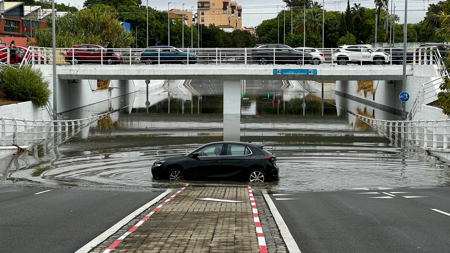 Vista del paso inferior de la calle Alfonso Lasso De la Vega, completamente inundado este miércoles tras las intensas lluvias en la capital sevillana