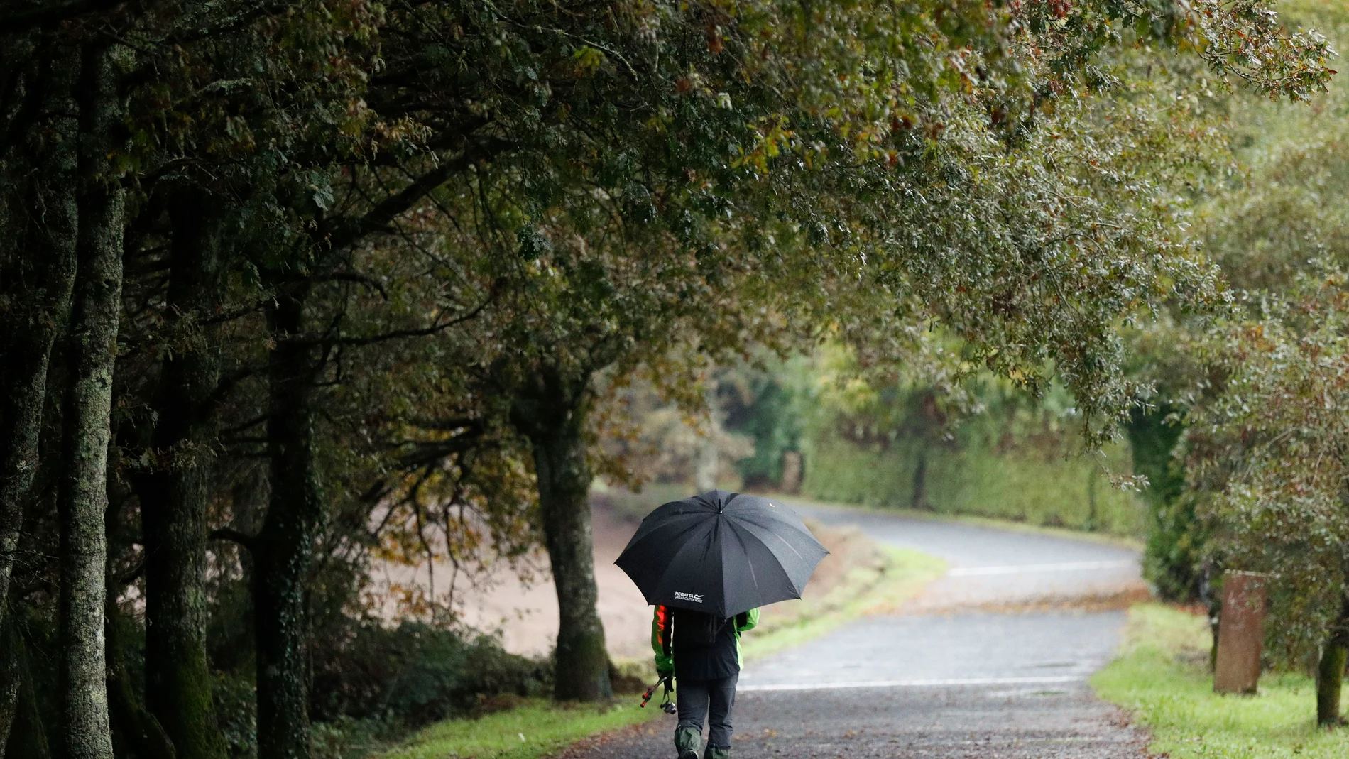 FOTODELDÍA PALAS DE REI (LUGO), 29/10/2025.- Una persona camina este miércoles en la localidad de Palas de Rei (Lugo). La influencia de una borrasca en el suroeste peninsular dejará este miércoles inestabilidad meteorológica en la Península y Baleares, con precipitaciones generalizadas en mitad occidental y más dispersas en el centro y nordeste peninsulares, así como chubascos localmente fuertes en los litorales de Cataluña, y un ascenso de las temperaturas mínimas.