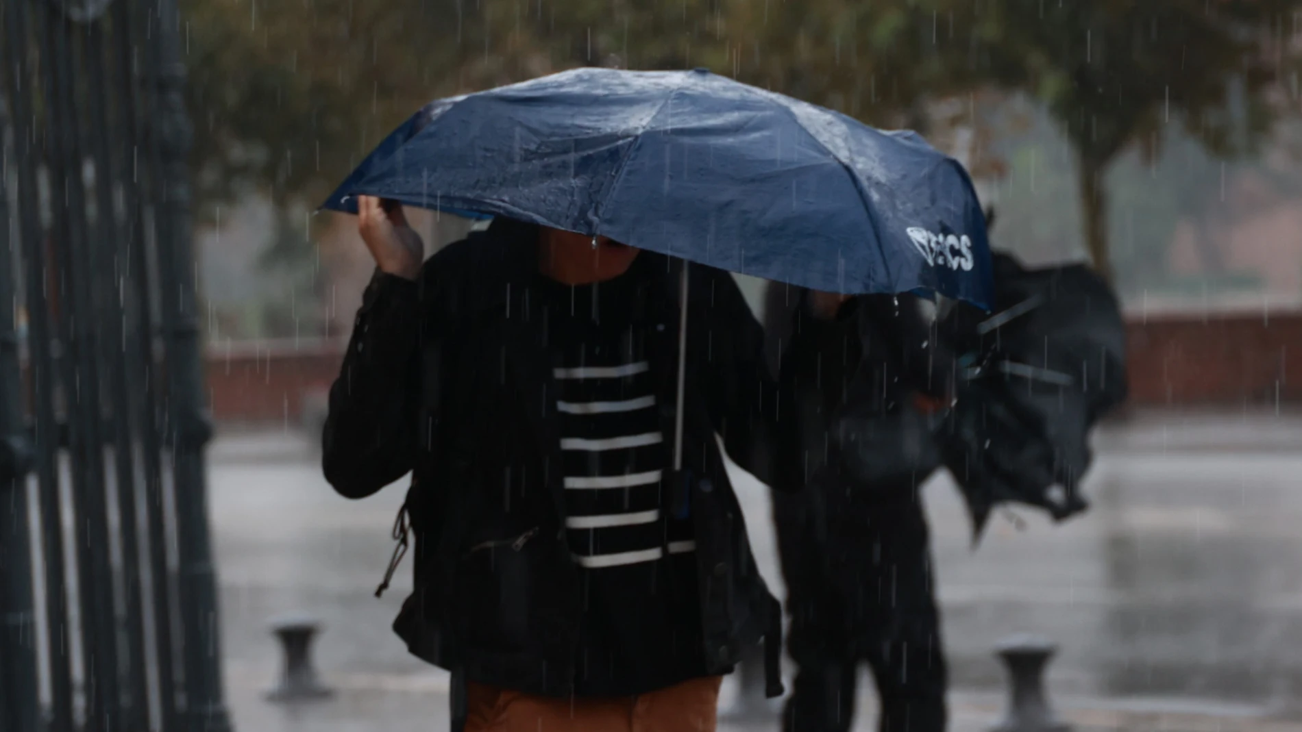 Una persona cubriéndose de la lluvia