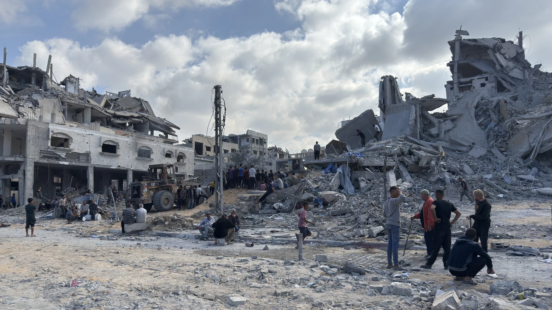 GAZA, 29/10/2025.-Un grupo de gazatíes observa los trabajos de rescate de cuatro personas (un padre y sus tres hijas), de entre los escombros tras un ataque aéreo israelí contra el edificio donde se refugiaban. Un total de 100 personas murieron, entre ellas 35 niños, en los bombardeos israelíes en la Franja palestina de Gaza, tras la reanudación anoche de los ataques del Ejército israelí en el enclave en lo que su Gobierno califica de violaciones del alto el fuego por Hamás.-EFE/ Ahmad Awad