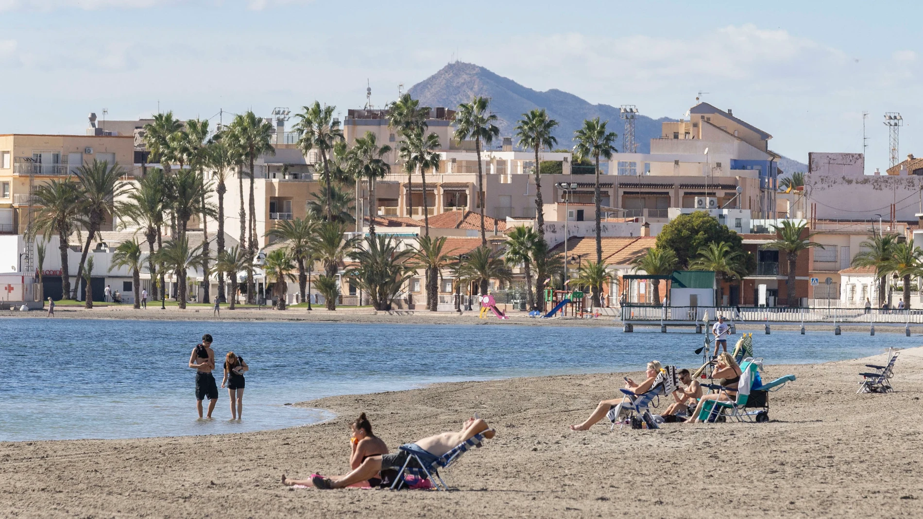 SAN PEDRO DEL PINATAR, (MURCIA), 06/11/2025.- Varias personas toman el sol en la playa Villananitos de San Perdo del Pinatar este jueves. La Agencia Estatal de Meteorología prevé para este jueves en la Región de Murcia cielos poco nubosos, con intervalos de nubes bajas matinales, las temperaturas máximas en descenso en el norte de la región; el resto, con cambios ligeros, y los vientos moderados de componente oeste. EFE/Marcial Guillén