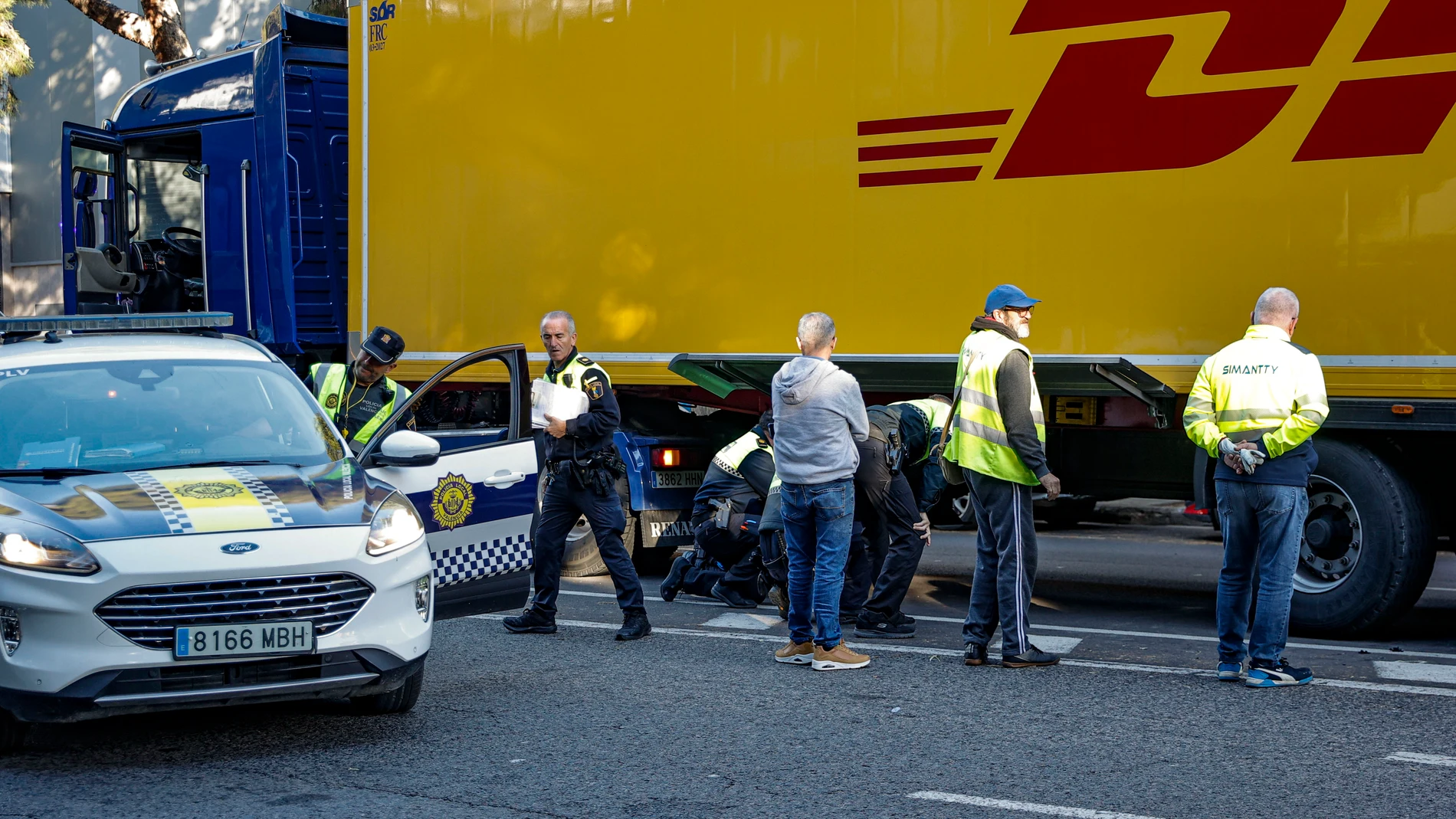 VALÈNCIA, 07/11/2025.- Una joven de 20 años ha fallecido a primera hora de esta mañana después de haber sido atropellada cuando cruzaba un paso de peatones con el semáforo en verde por un camión cuyo conductor ha dado positivo en cannabis y cocaína. En la imagen, agentes de atestados de la Policía Local de València junto al camión en el lugar del atropello. EFE/Manuel Bruque