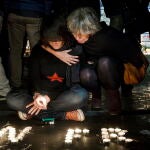 Personas encienden velas en la Plaza de la República en París, en homenaje a las víctimas de los atentados del 13-N en París