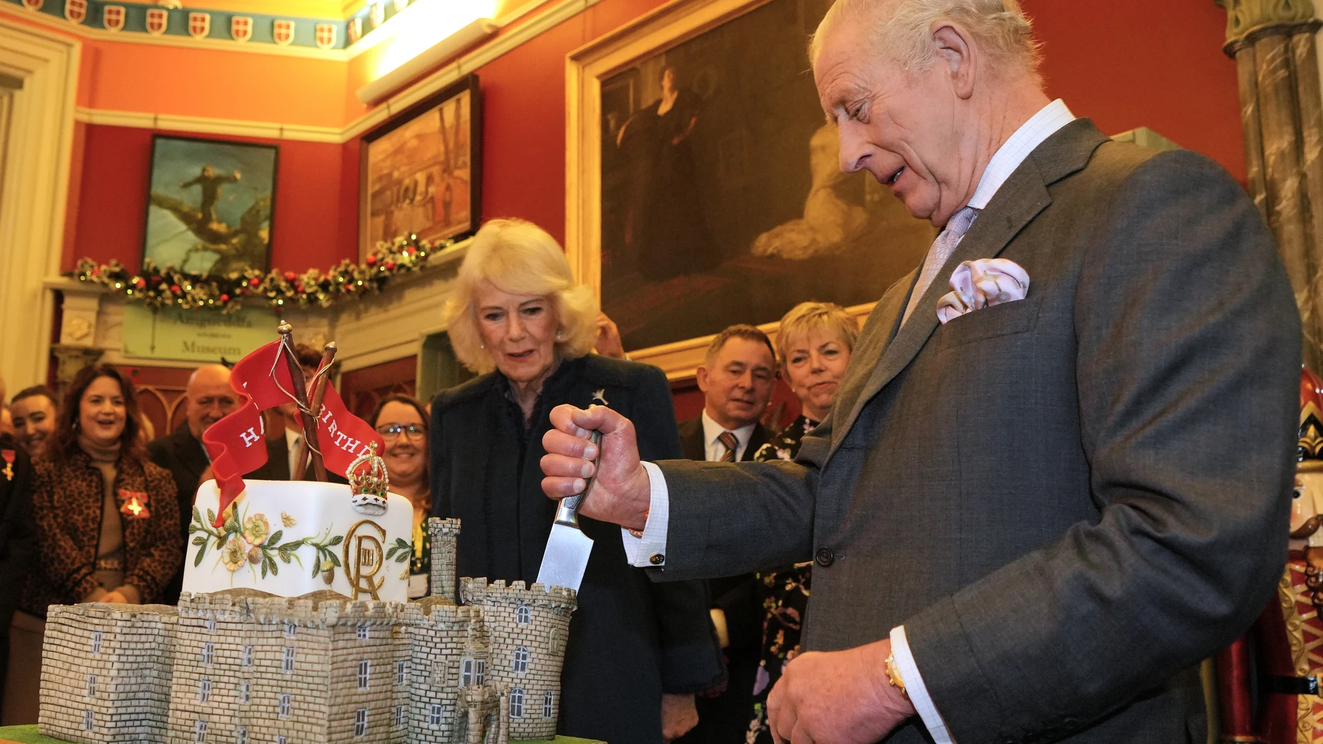 Britain's King Charles III and Queen Camilla cut a cake in the shape of the castle as they join a celebratory reception marking Cyfarthfa Castle's 200th anniversary and the King's birthday in Merthyr Tydfil, Wales, Friday, Nov. 14, 2025.(AP Photo/Kin Cheung, Pool)