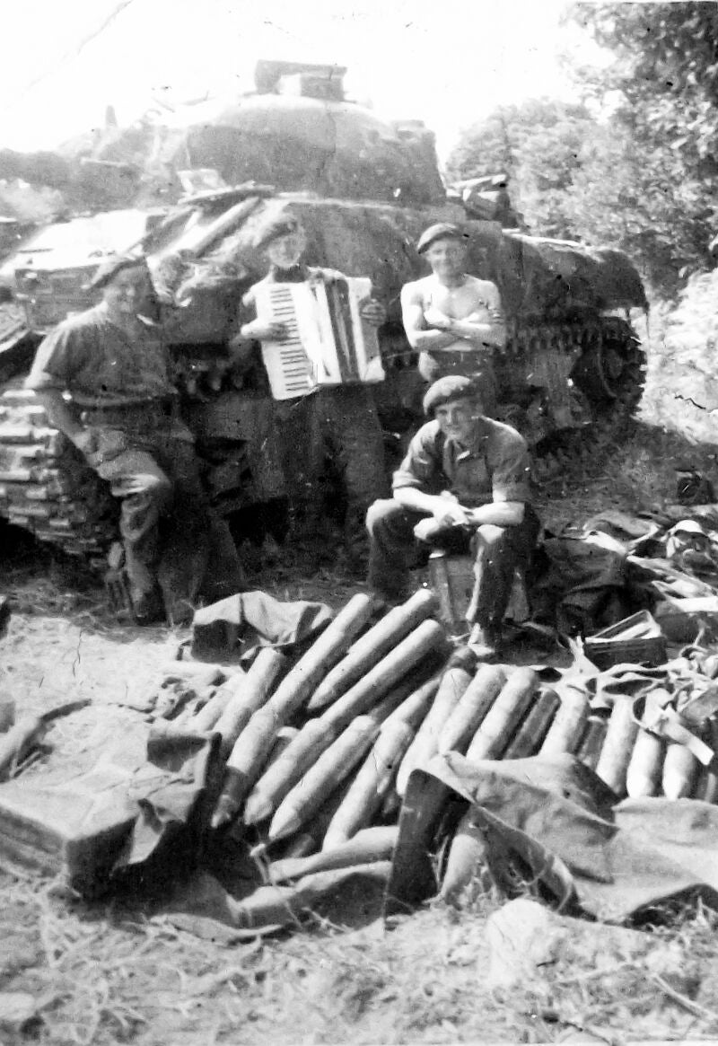 John Bennett toca el acordeón para distraer a sus compañeros durante un descanso