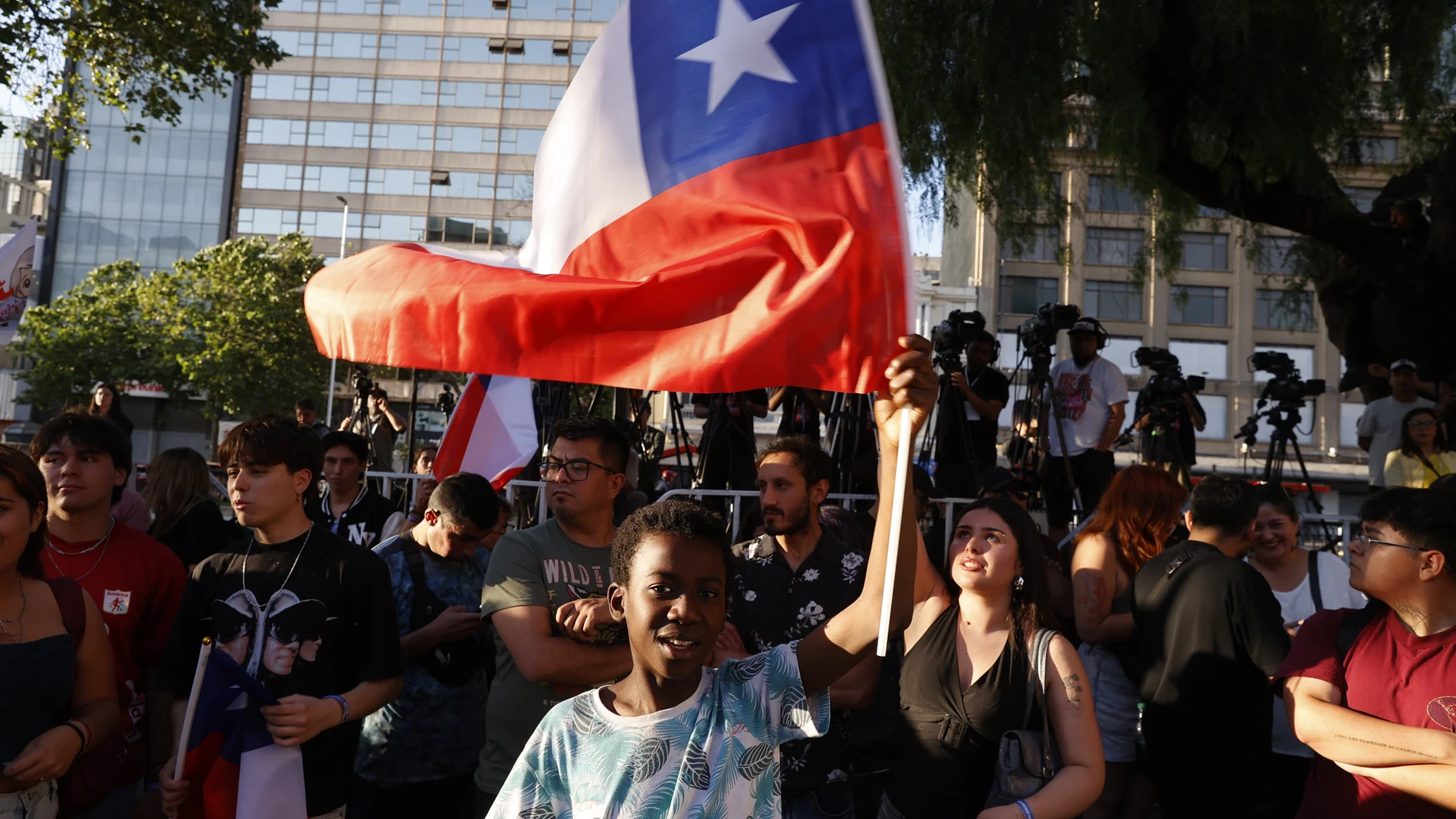 AME9776. SANTIAGO (CHILE), 16/11/2025.- Un simpatizante de la candidata a la Presidencia de Chile por el partido Unidad por Chile, Jeannette Jara, sostiene una bandera este domingo, en Santiago (Chile). Los colegios electorales de Chile cerraron sus puertas para arrancar el conteo de votos en unas presidenciales que previsiblemente no se resolverán en primera vuelta y a las que llega como favorita la candidata única del progresismo, Jeannette Jara, pero aparentemente sin el apoyo suficiente p...