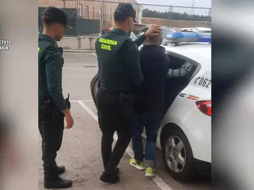 Dos agentes de la guardia civil con un detenido Dos agentes de la guardia civil con un detenido