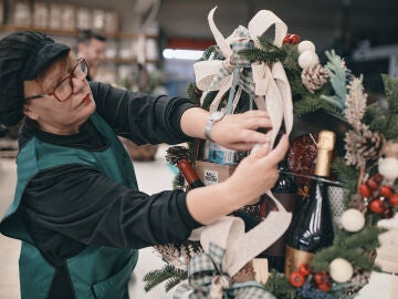Una trabajadora de Grupo Disber ultima los detalles de una cesta de Navidad