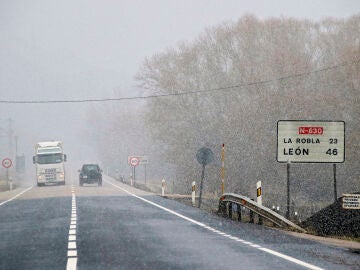 Varios veh&iacute;culos circulan por una carretera nevada de Le&oacute;n