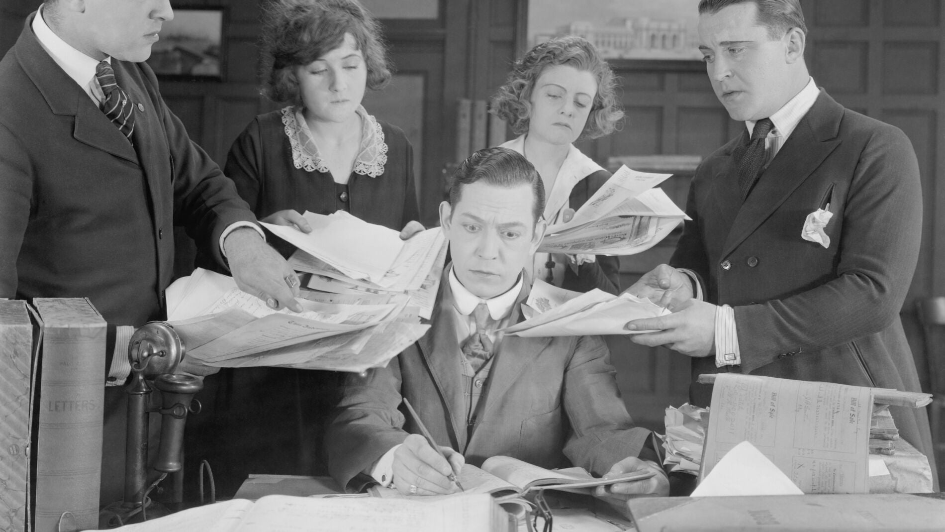 Toma de decisiones empresariales. Fotografía vintage en blanco y negro que representa un responsable acosado por papeleo de sus trabajadores