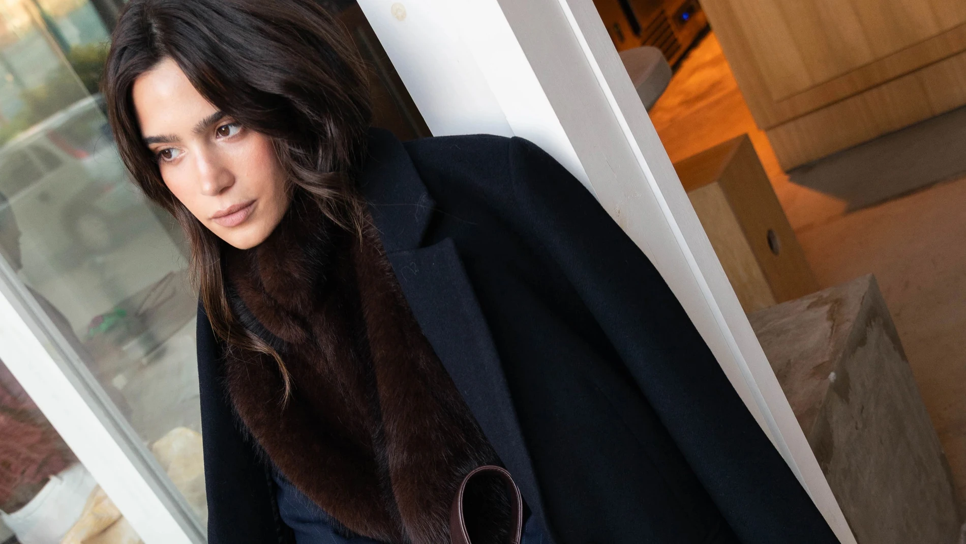 Mujer con abrigo de lana oscuro en un look urbano de invierno