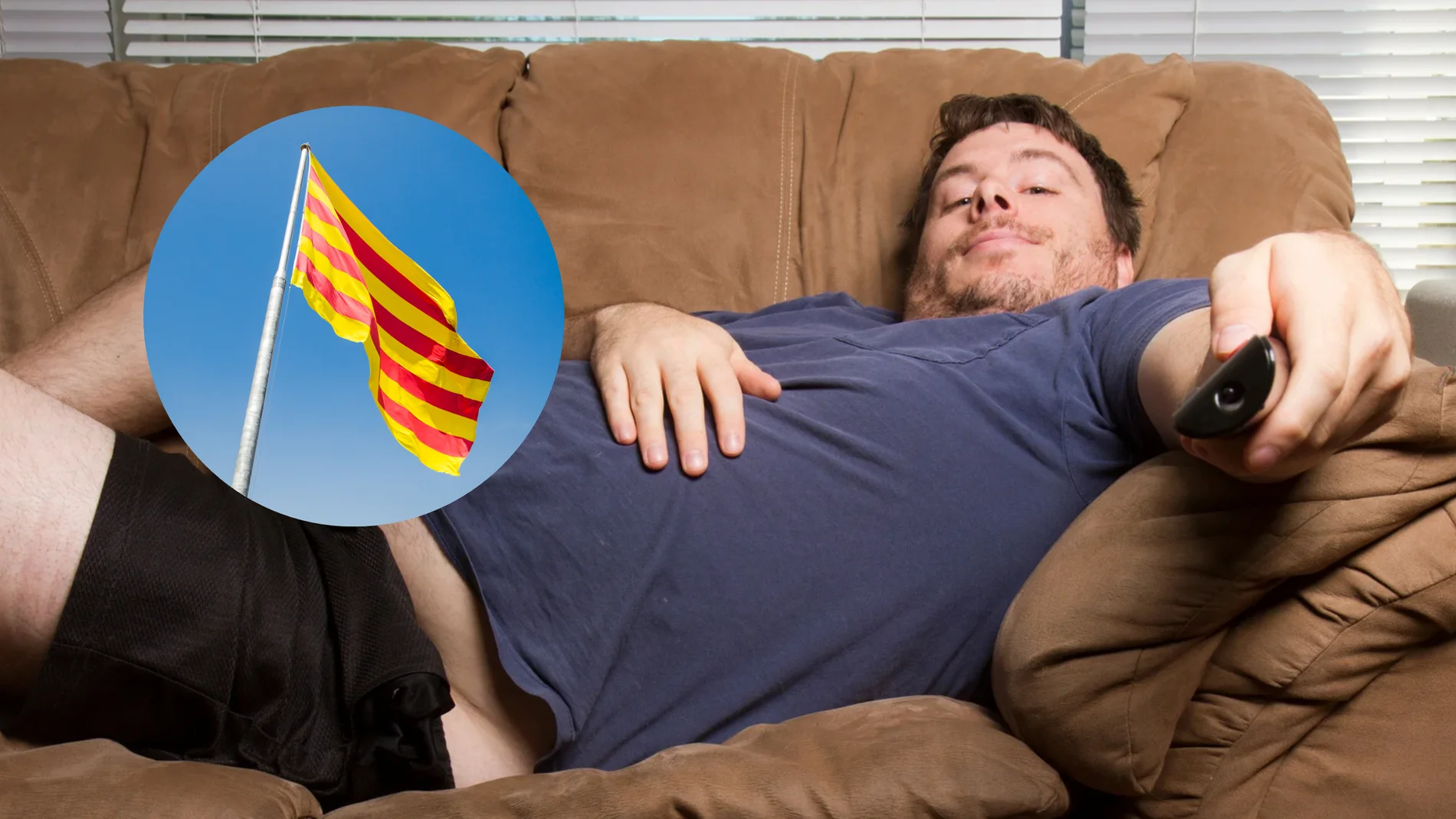 Una persona tirada en el sofá junto con la bandera de Cataluña