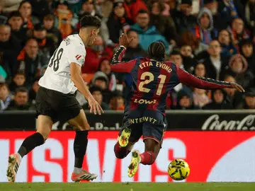 VALENCIA / LEVANTE VALENCIA, 21/11/2025.- El delantero camerunés del Levante, Karl Etta Eyong (d), cae el centrocampista del Valencia, Pepelu, durante el encuentro correspondiente a la jornada 13 de Laliga EA Sports que disputan hoy viernes Valencia y Levante en el estadio valencianista de Mestalla. EFE / Manuel Bruque.