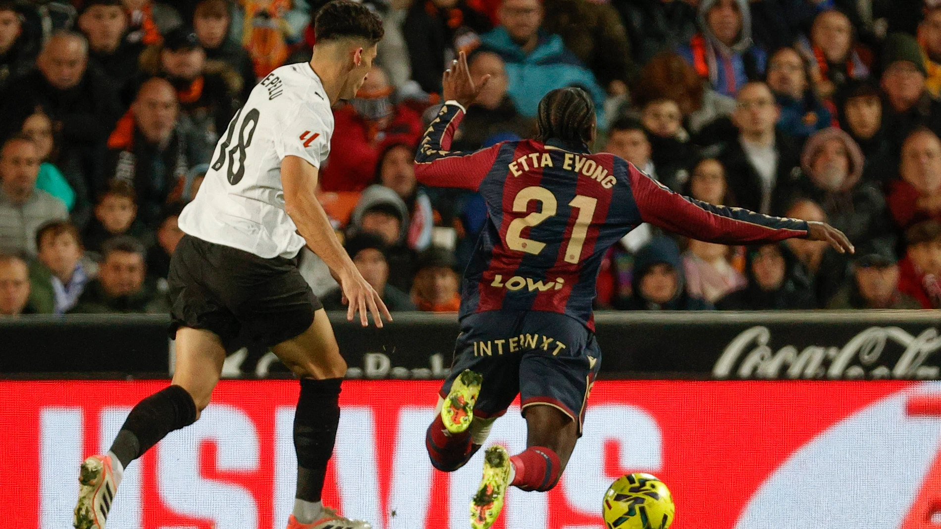 VALENCIA, 21/11/2025.- El delantero camerunés del Levante, Karl Etta Eyong (d), cae el centrocampista del Valencia, Pepelu, durante el encuentro correspondiente a la jornada 13 de Laliga EA Sports que disputan hoy viernes Valencia y Levante en el estadio valencianista de Mestalla. EFE / Manuel Bruque.