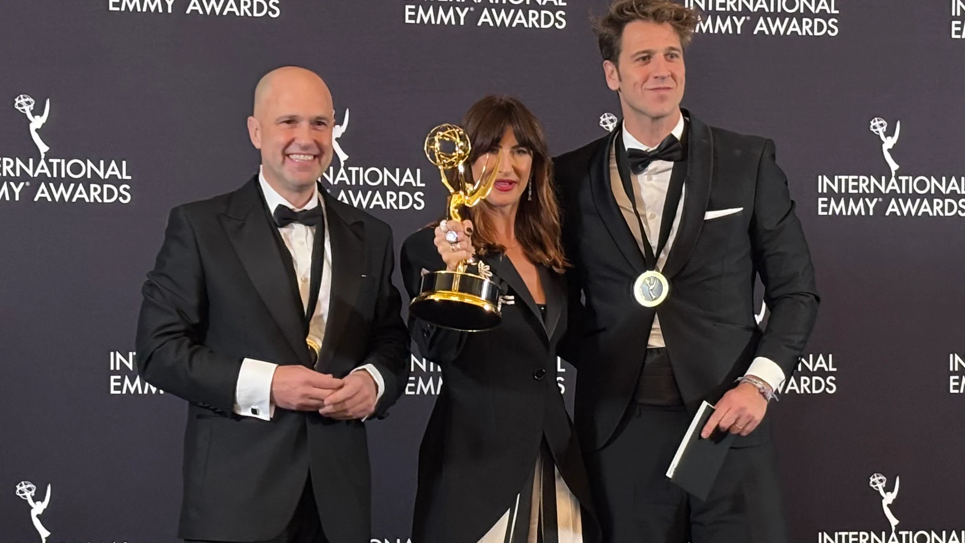 AME2405. NUEVA YORK (ESTADOS UNIDOS), 24/11/2025.- La directora del documental ‘#SeAcabó: Diario de las campeonas' Joanna Pardos (c) y los productores ejecutivos Luis Calvo (i) y Javier Martínez Suárez (d), posan con el premio a mejor documental deportivo este lunes, durante la entrega de los premios Emmy Internacionales en Nueva York (Estados Unidos). El documental que relata el caso Rubiales, '#SeAcabó: Diario de las campeonas', dirigido por Pardos, ganó en Nueva York el Premio Emmy Interna...