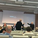 El decano del COAM, sigfrido Herráez (sentado), y otro miembro del Colegio, se enfrentan a Jesús San Vicente (en el centro), durante el acto de toma de posesión