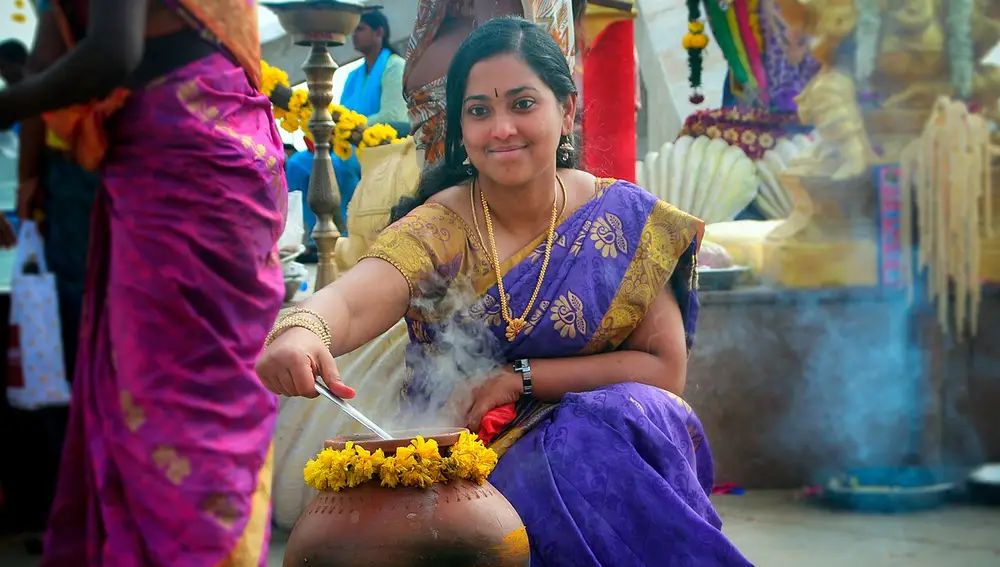Una joven prepara un plato de Pongal durante las celebraciones