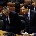 El presidente de la Junta de Andalucía, Juanma Moreno (d), se sienta junto al consejero de Presidencia y Sanidad, Antonio Sanz (i), en el Parlamento andaluz