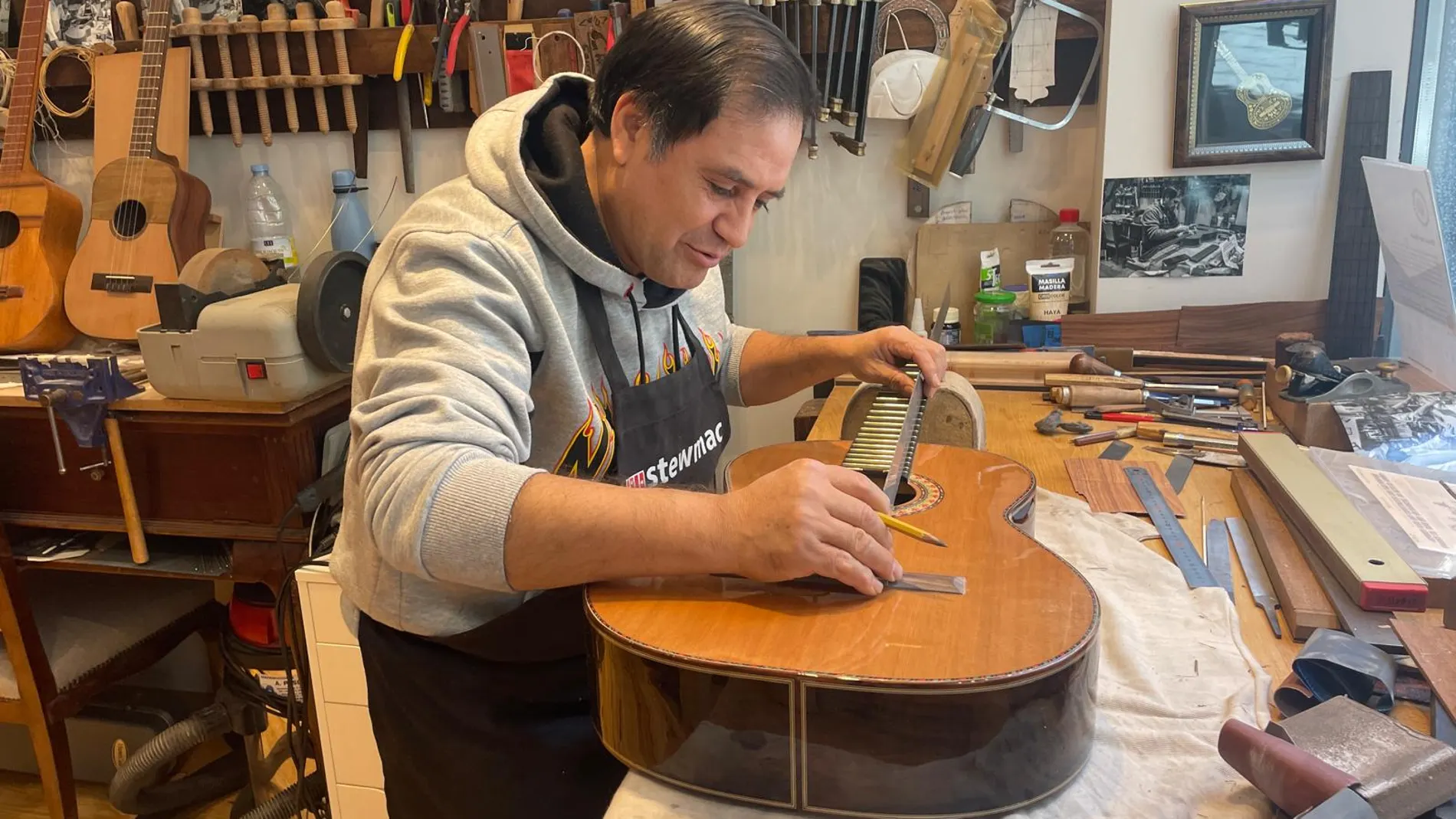 Benigno Marín, el guitarrero que trabaja desde hace 30 años para la marca de Manuel Rodríguez, mide con una regla la altura idónea de la cejuela antes de colocar las cuerdas