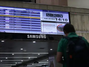 Principal aeropuerto de Venezuela sigue funcionando pese al anuncio de Trump AME4070. MAIQUETIA (VENEZUELA), 29/11/2025.- Una persona camina junto a una pantalla con la programación de vuelos este sábado, en el Aeropuerto Internacional Simón Bolívar en Maiquetia (Venezuela). El Simón Bolívar mantiene con normalidad sus operaciones después del anuncio del presidente de EE. UU., Donald Trump, de considerar el espacio aéreo de este país suramericano cerrado. EFE/ Ronald Pena R