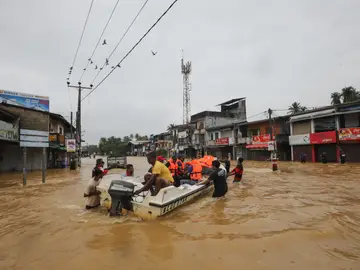 Víctimas de las inundaciones en Sri Lanka caminan por una carretera inundada durante las fuertes lluvias en un suburbio de Colombo Víctimas de las inundaciones en Sri Lanka caminan por una carretera inundada durante las fuertes lluvias en un suburbio de Colombo