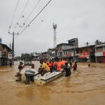 Víctimas de las inundaciones en Sri Lanka caminan por una carretera inundada durante las fuertes lluvias en un suburbio de Colombo