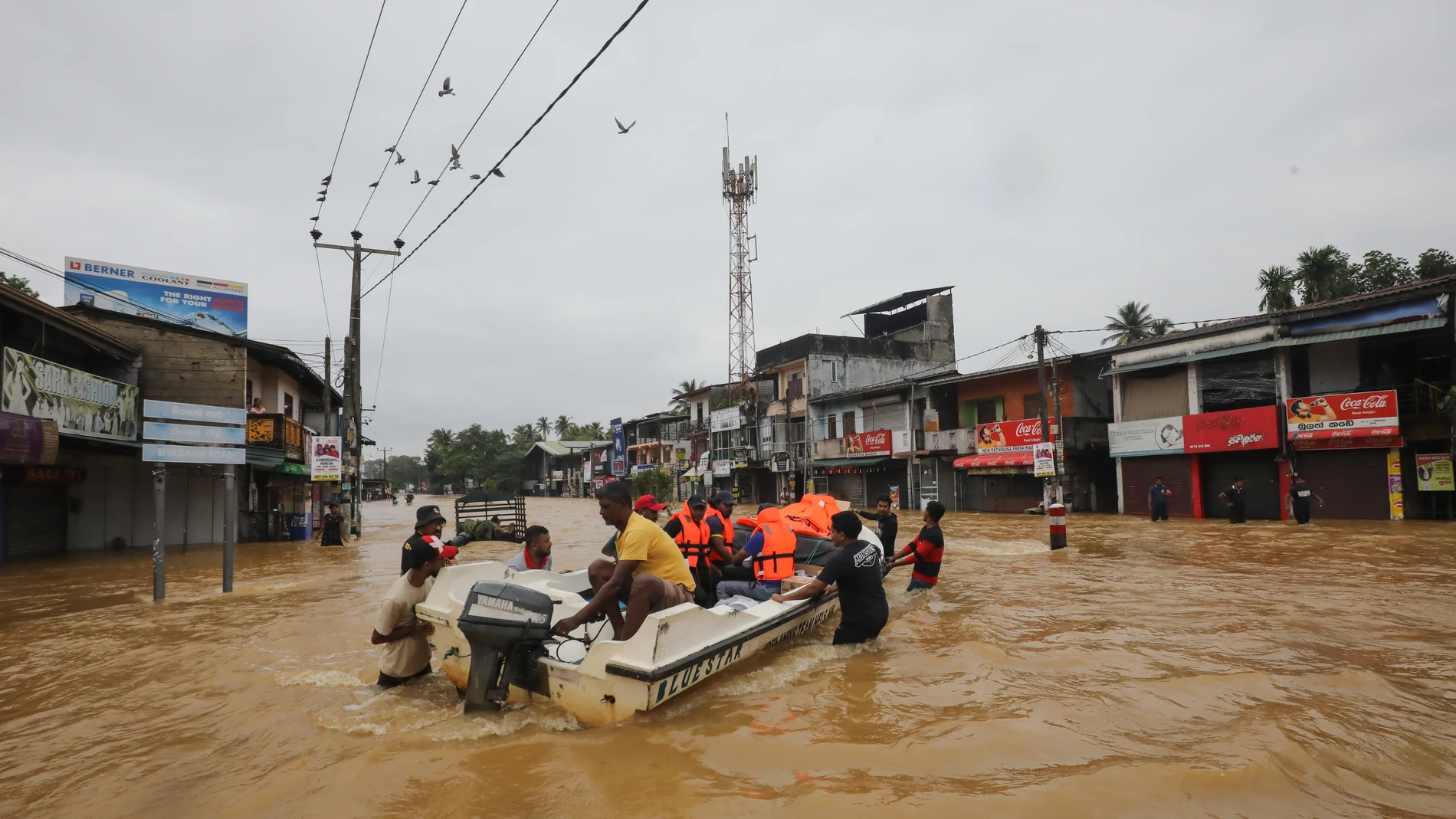 Víctimas de las inundaciones en Sri Lanka caminan por una carretera inundada durante las fuertes lluvias en un suburbio de Colombo