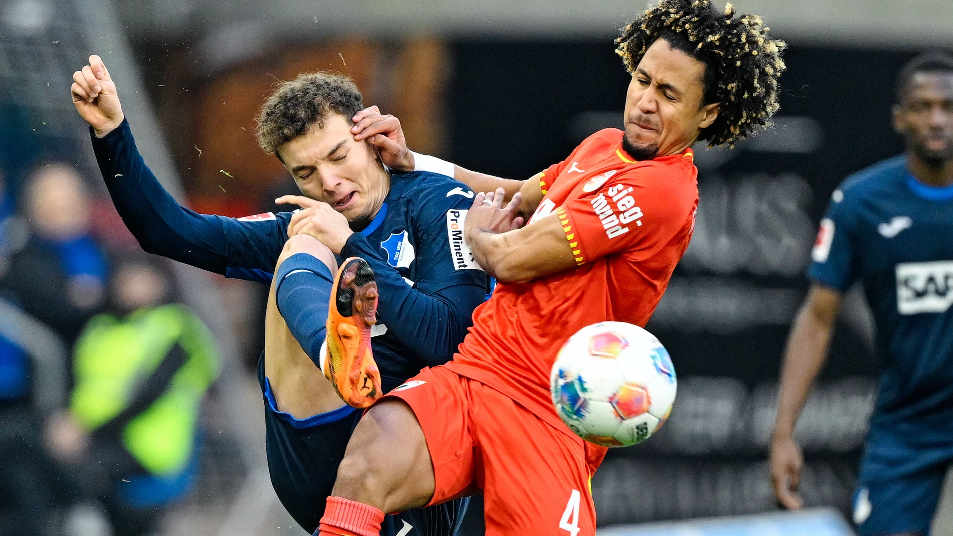 Hoffenheim's Fisnik Asllani, left, and Augsburg's Han-Noah Massengo in action during the Bundesliga soccer match between TSG 1899 Hoffenheim and FC Augsburg in Sinsheim, Germany, Saturday Nov. 29, 2025. (Uwe Anspach/dpa via AP)