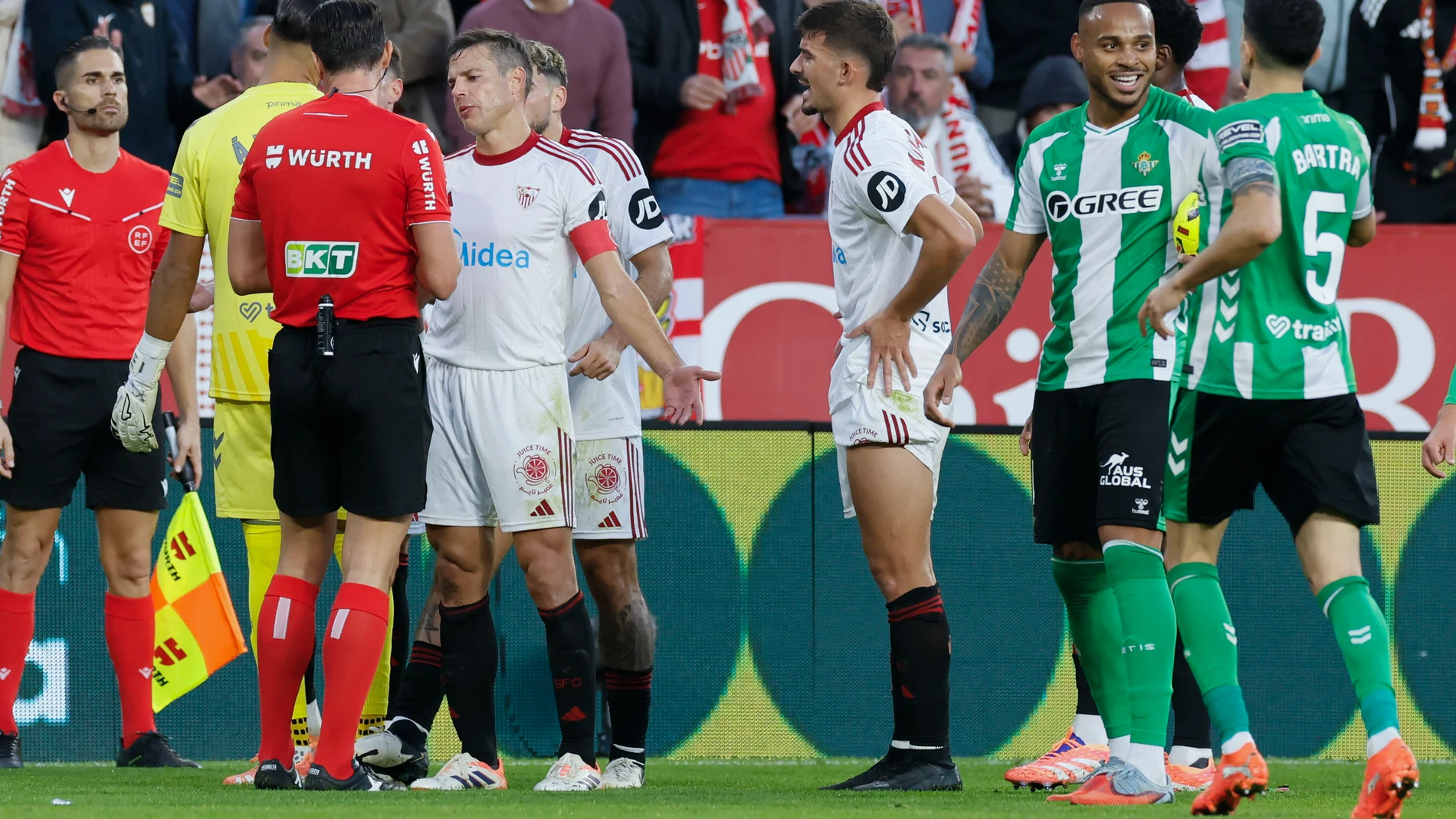 SEVILLA, 30/11/2025.- El defensa del Sevilla César Azpilicueta (4i) conversa con el colegiado José Luis Munuera Montero (3i) durante el partido de LaLiga entre Sevilla FC y Real Betis celebrado este domingo en el Estadio Ramón Sánchez-Pizjuán de Sevilla. EFE/ José Manuel Vidal
