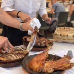Camareros del Asador San Lorenzo de Burgos, nuevo Solete Repsol, parten unos cuartos de lechazo