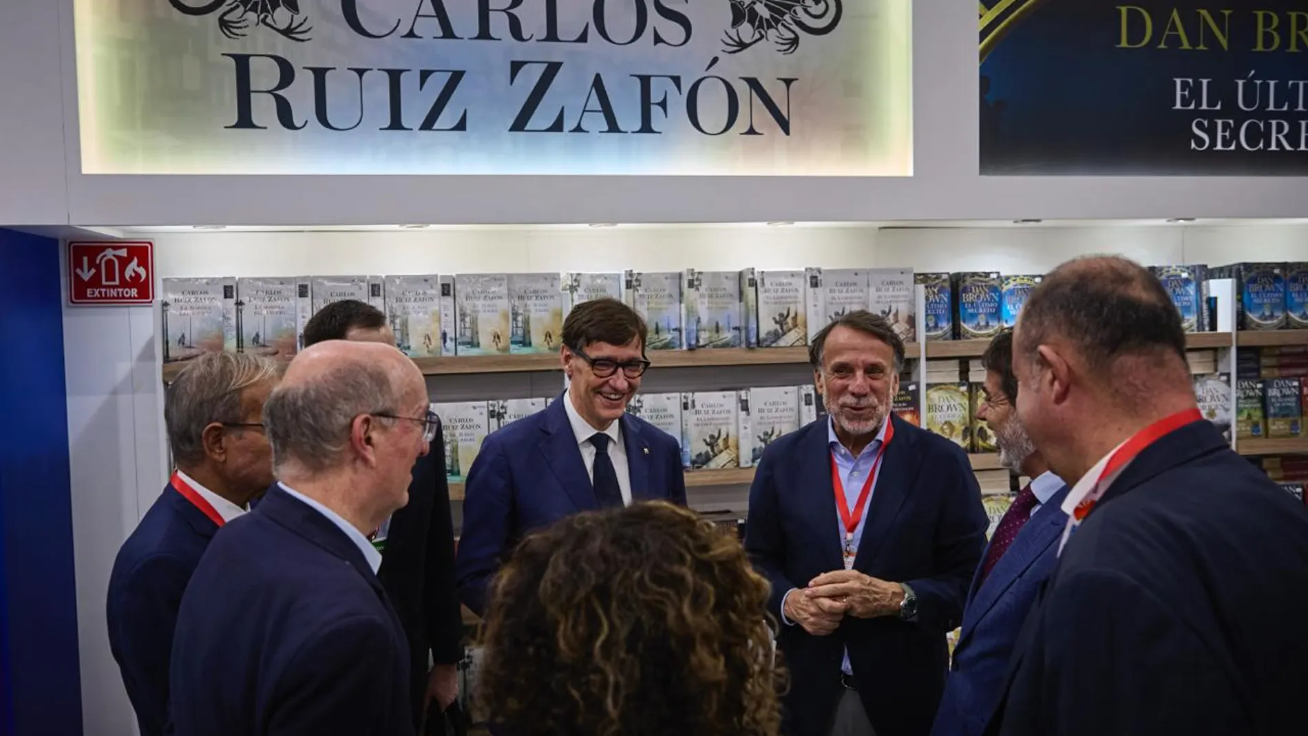 Salvador Illa, presidente de la Generalitat, junto a José Creuheras, presidente del Grupo Planeta y Atresmedia, frente al stand dedicado a Carlos Ruiz Zafón