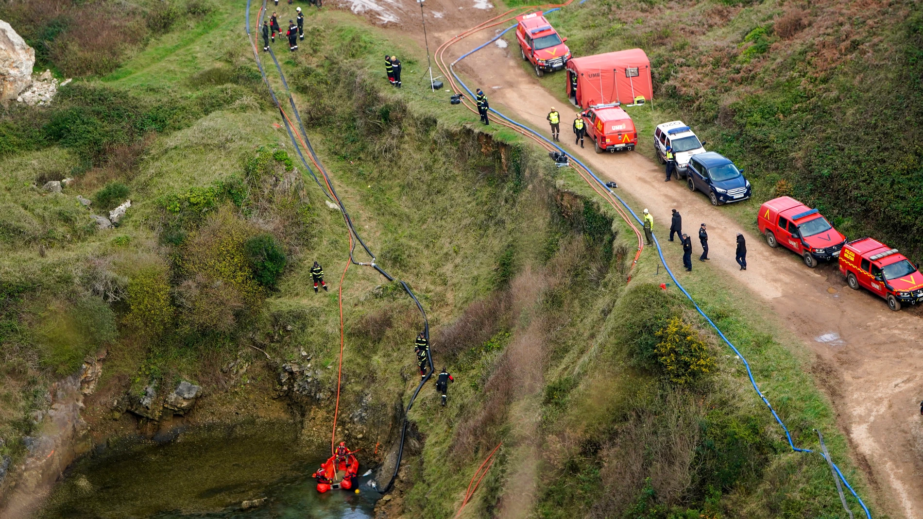Efectivos de la Unidad Militar de Emergencias (UME) y de la Policía Nacional continúan este miércoles con la búsqueda de los cuerpos de la mujer y de su bebé desaparecidos en la provincia de León en el año 1987 en la balsa de una antigua mina de fluorita situada en Berbés, parroquia del concejo asturiano de Ribadesella. EFE/ Paco Paredes