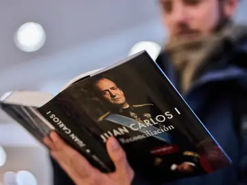 Spain King's Memoirs A man reads "Reconciliacion", the newly released memoir of former Spanish King Juan Carlos I, inside a bookstore in Madrid, Spain, Wednesday, Dec. 3, 2025. (AP Photo/Manu Fernandez)