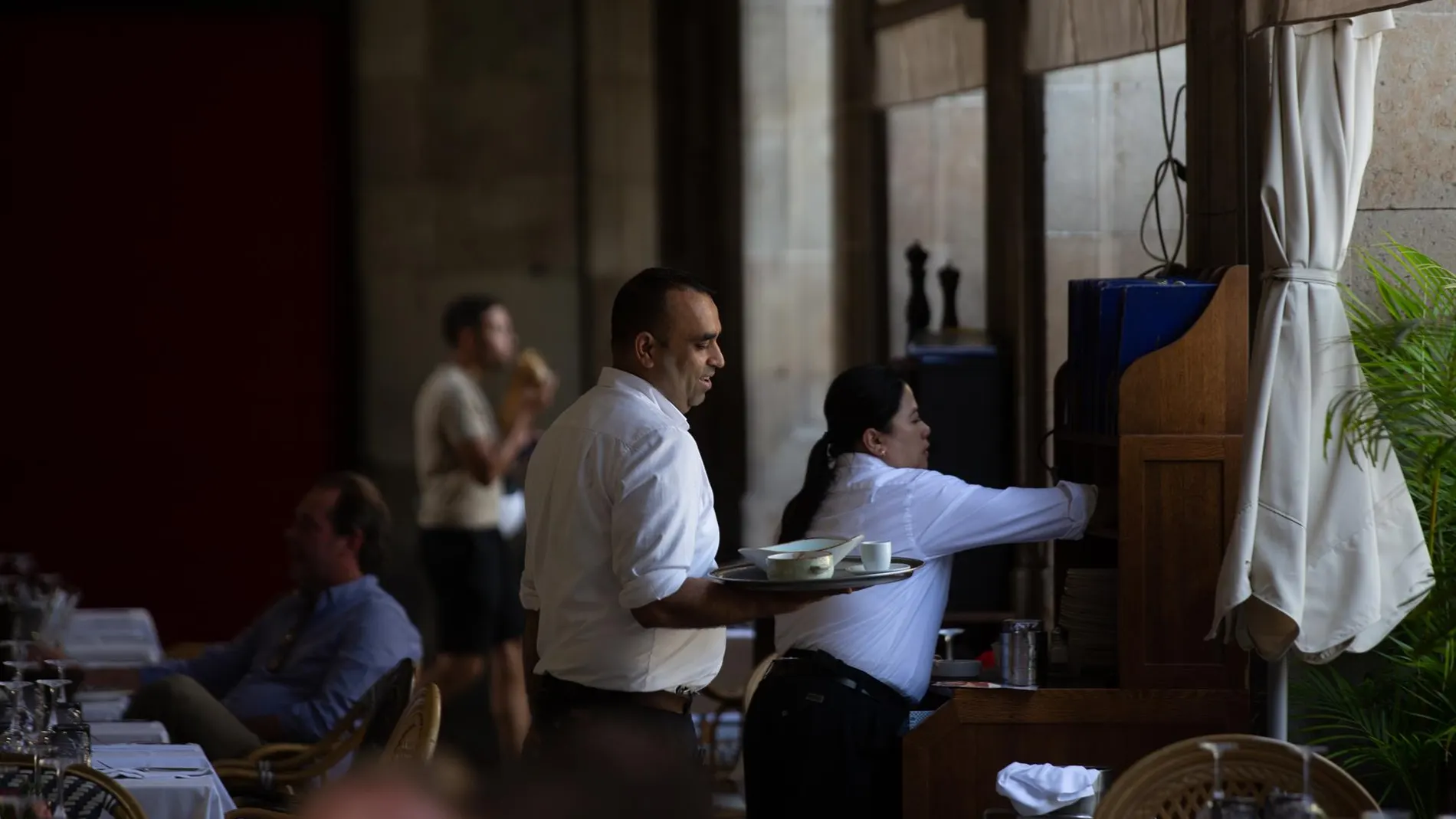 Un camarero sostiene una bandeja en la plaza Real de Barcelona