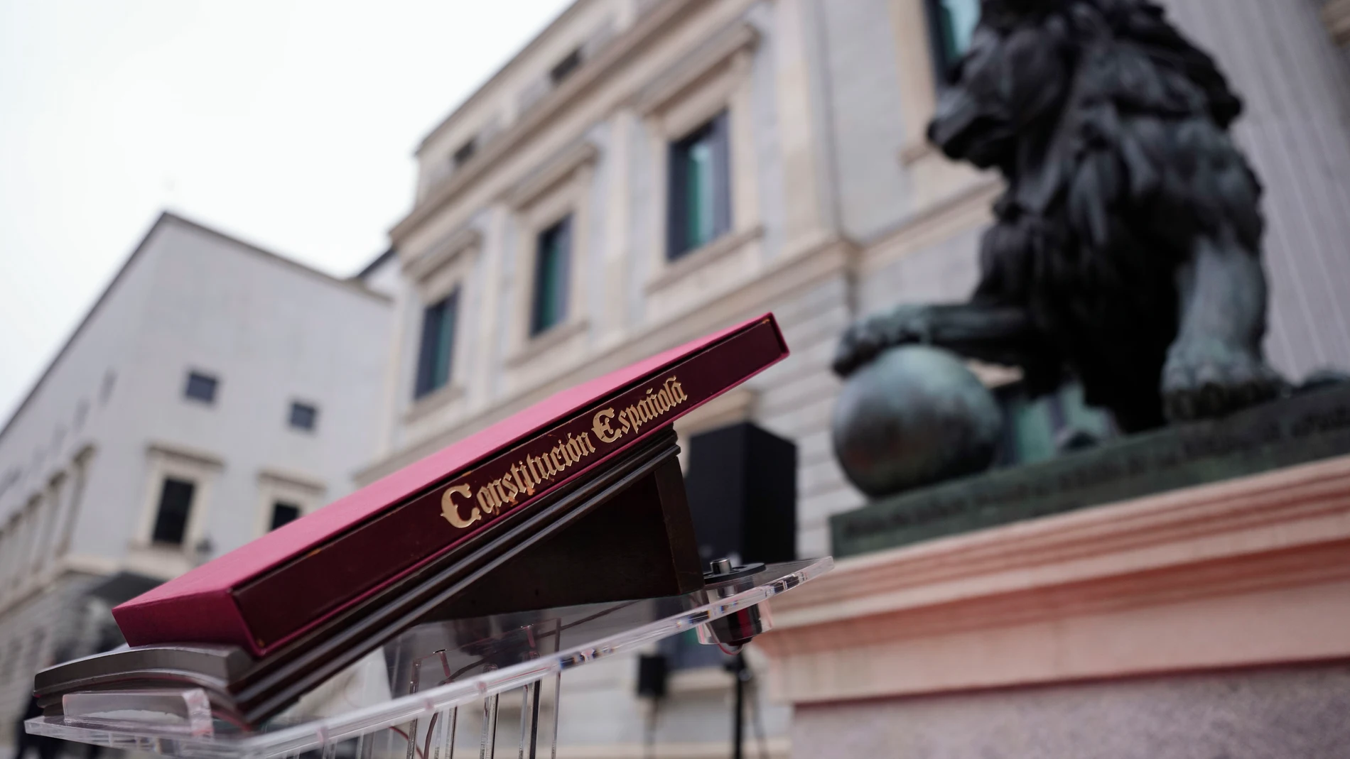 MADRID, 06/12/2025.- Ejemplar de la Constitución Española colocado ante los leones que custodian la entrada principal del Congreso de los Diputados antes del acto institucional por el Día de la Constitución, al que asistirán el presidente del Gobierno, Pedro Sánchez, y el líder de la oposición, Alberto Núñez Feijóo, entre otros dirigentes políticos, en una jornada marcada este año por una profunda división política, con la crispación en máximos y en medio de un ambiente electoral por el arran...