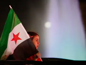 Una niña sostiene una bandera siria en Damasco durante el primer aniversario de la caída de Bachar al Asad A girl holds a Syrian flag during celebrations of the first anniversary of the ousting of the Bashar Assad regime in Damascus, Syria, early Saturday, Dec. 6, 2025. (AP Photo/Ghaith Alsayed)
