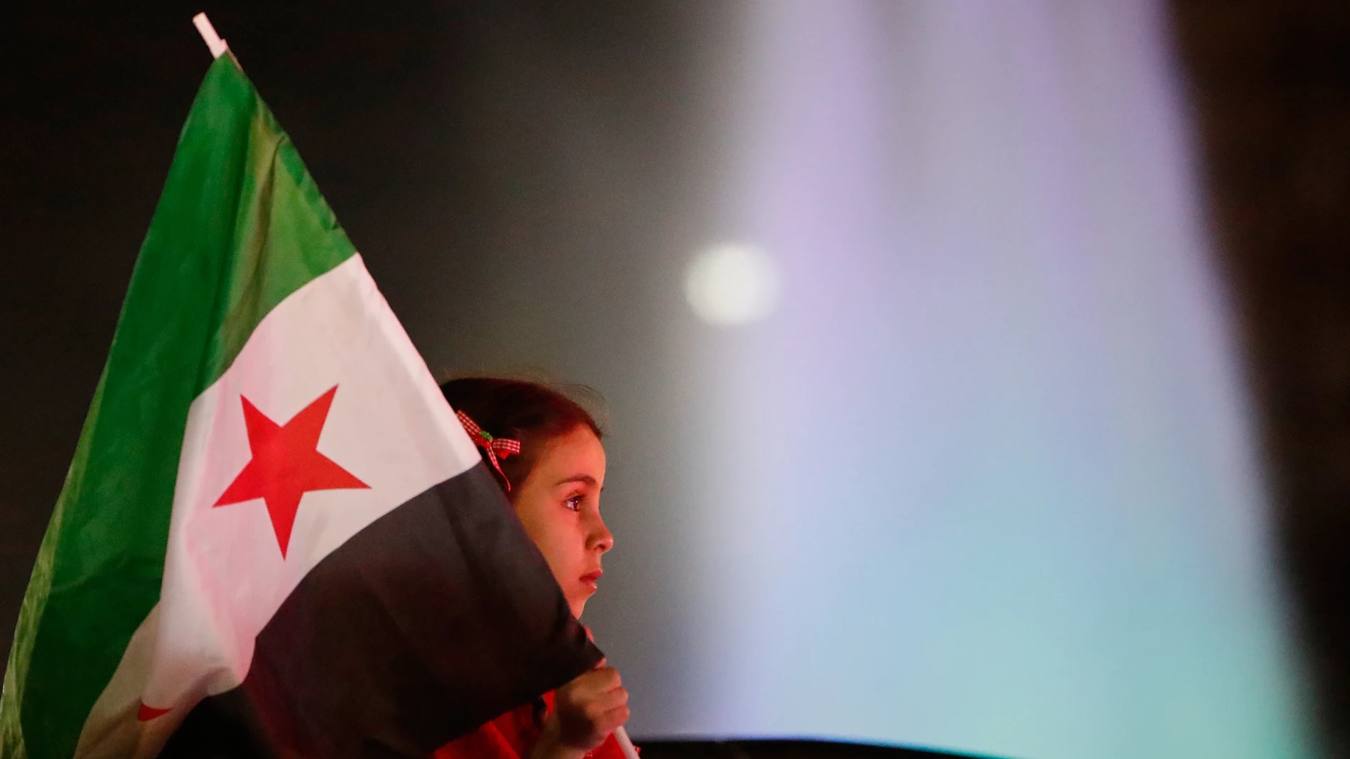 A girl holds a Syrian flag during celebrations of the first anniversary of the ousting of the Bashar Assad regime in Damascus, Syria, early Saturday, Dec. 6, 2025. (AP Photo/Ghaith Alsayed)