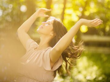 Mujer al aire libre recibiendo vitamina D del sol, asociada a longevidad, salud &oacute;sea e inmunidad