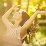 Mujer al aire libre recibiendo la luz del sol, s&iacute;mbolo de la s&iacute;ntesis natural de vitamina D