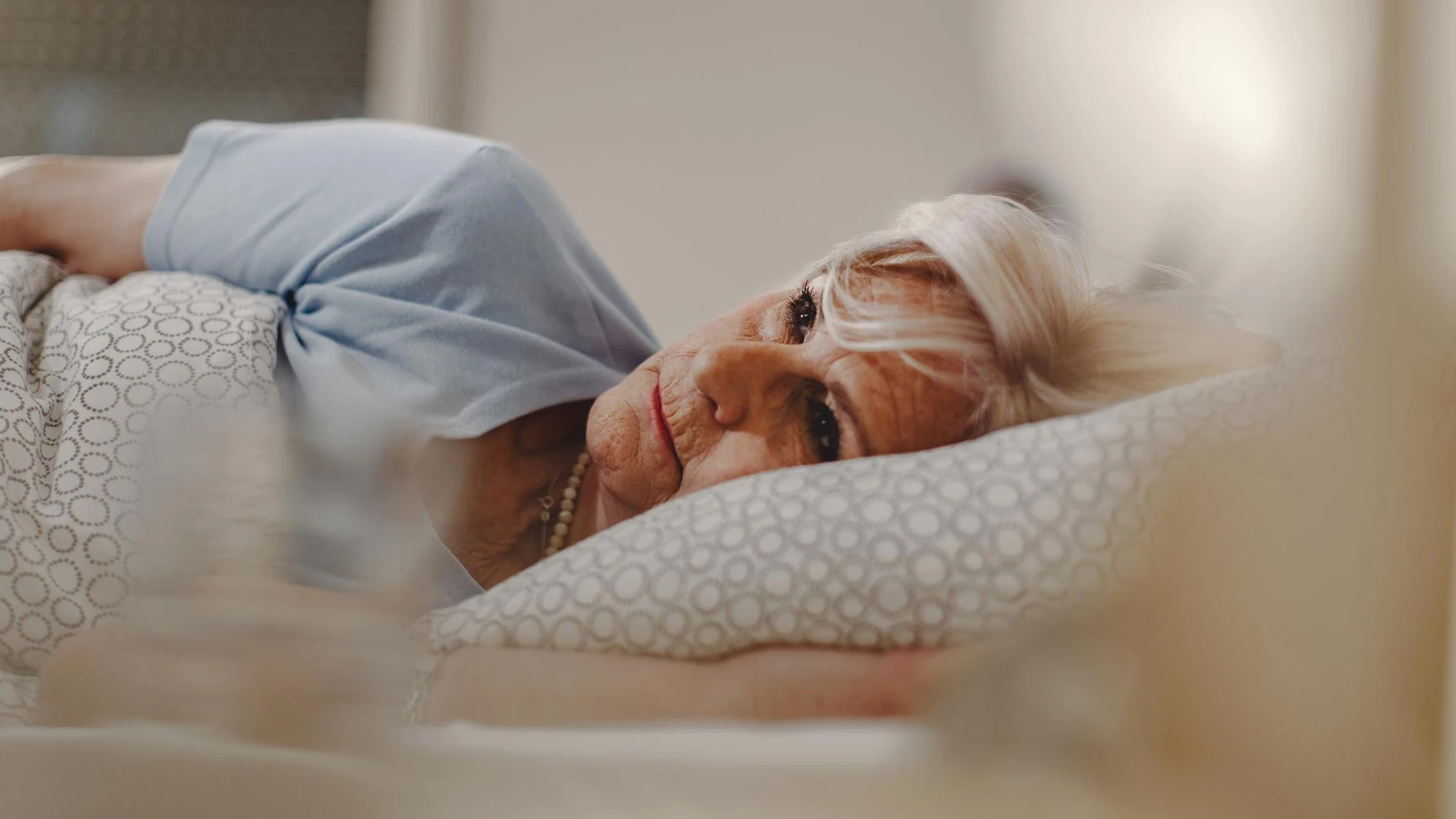 Persona mayor de 65 años en la cama para dormir por la noche a temperatura ambiente