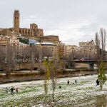 Varias personas disfrutan de la nieve ca&iacute;da en Lleida, este lunes